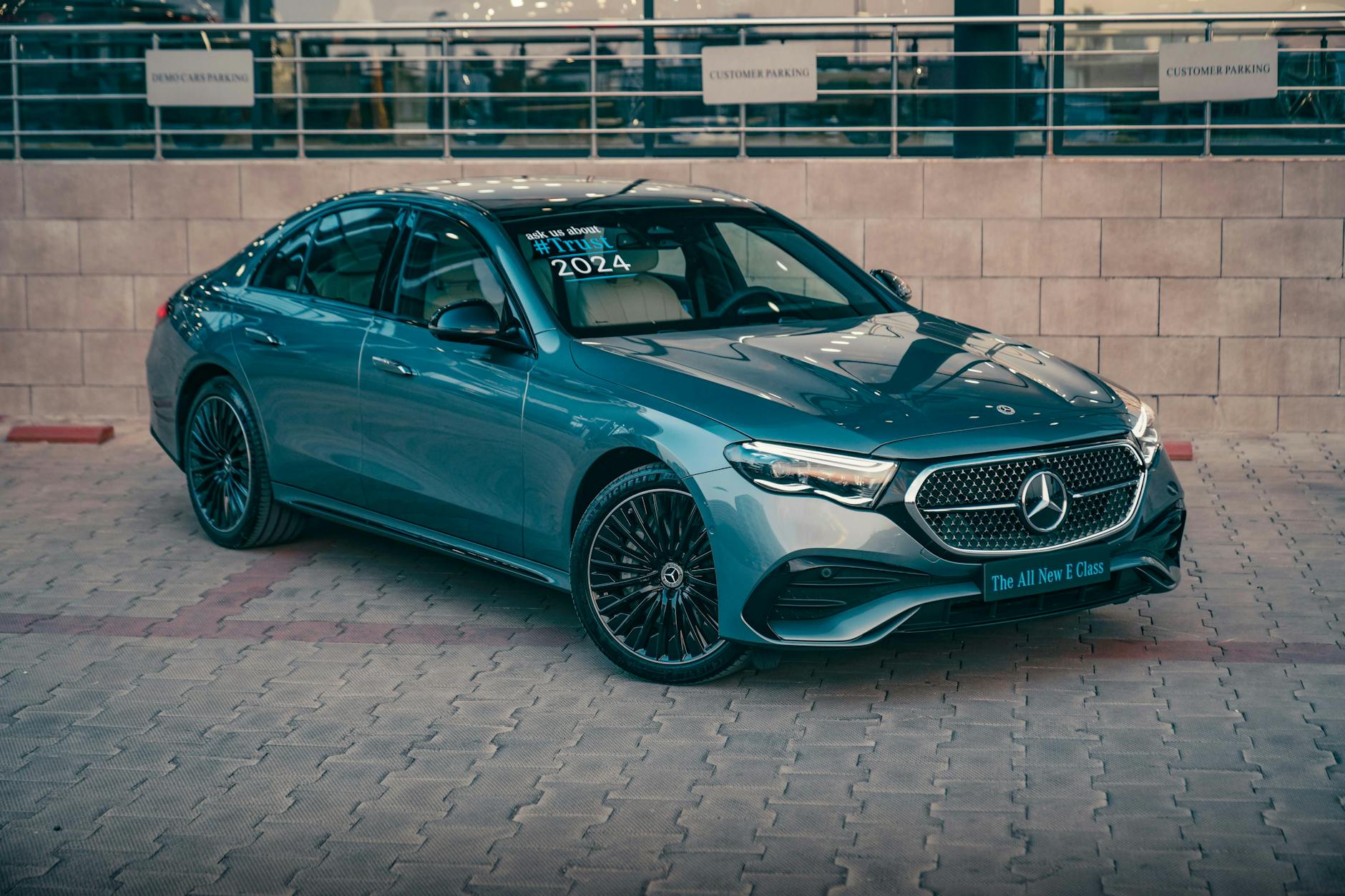 Experience elegance with the 2024 Mercedes E-Class luxury sedan parked in a stylish urban setting.